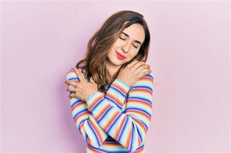 Young Hispanic Girl Wearing Casual Clothes Hugging Oneself Happy And Positive Smiling Confident