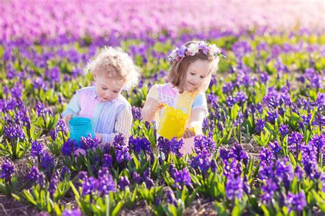 Kids Plant And Water Flowers In Spring Garden Stock Photo