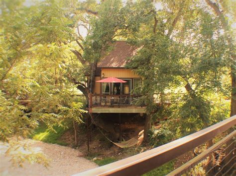Large log cabin featuring spacious living & dining room with gas fireplace, two downstairs bedrooms with queen beds, a loft with two queen beds and two full bathrooms. Stay in a Luxury Tree House by the Guadalupe River in ...