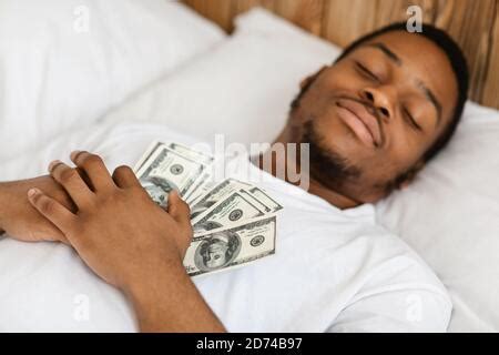 African Man Sleeping Holding Money Lying In Bed At Home Stock Photo Alamy