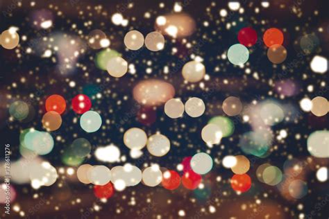 Christmas Lights Blurred Bokeh With Snowfall Background From Night