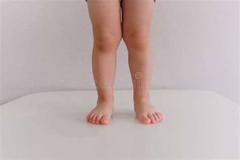 Baby Legs And Bottom In Leopard Coloring Diaper In Bed Stock Image
