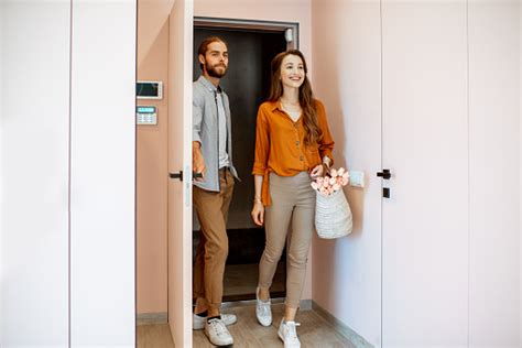 Young Couple Entering Home In The Corridor Of The Modern Flat Stock