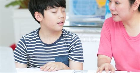 serious asian mother with son doing homework in the living room stock video video of sitting
