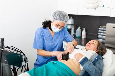 Cosmetologist Performing Ultrasound Cavitation Body Procedure For