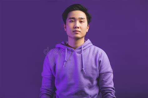 Portrait Of A Handsome Asian Man Posing Over Purple Violet Studio