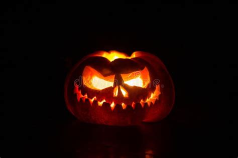 Close Up View Of Scary Halloween Pumpkin With Eyes Glowing Inside At