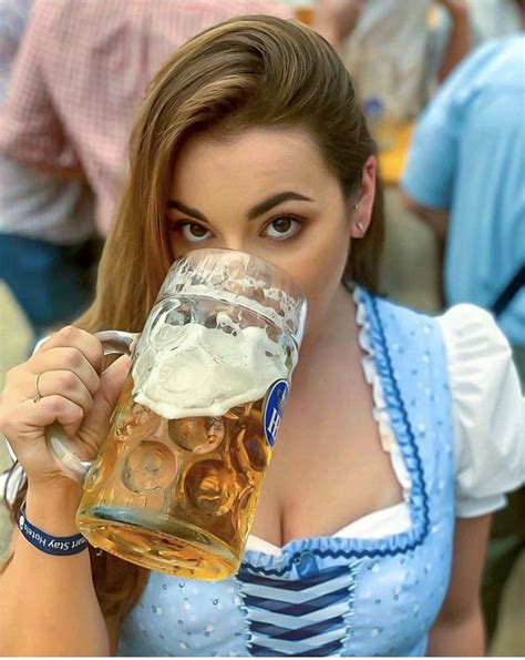 A Woman In A Blue Dress Holding A Beer Mug