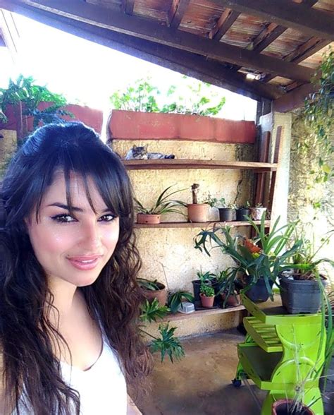 A Woman Standing In Front Of Some Potted Plants