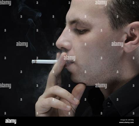 Young Man Smokes A Cigarette Stock Photo Alamy
