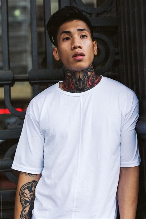 View Portrait Of A Young Asian Tattooed Man Standing Outside By