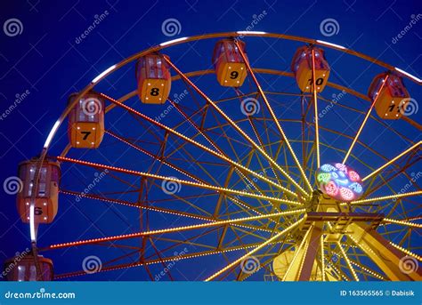 Illuminated Ferris Wheel In Amusement Park At A Night City Stock Image