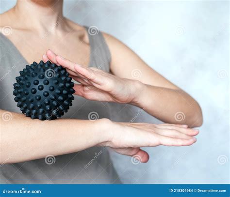 A Young Woman Massages Her Elbow With A Spiky Trigger Point Ball