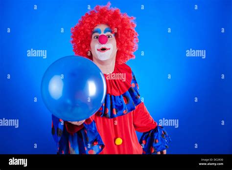 Happy Clown With Balloon On Blue Background Studio Inside Shot Stock