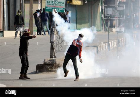 A Kashmiri Muslim Protester Throws A Teargas Canister Back At Indian