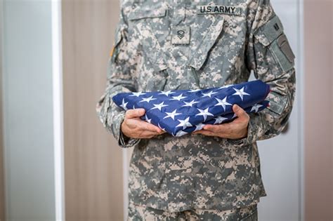 Soldier Presenting Usa Flag Folded Stock Photo Download Image Now