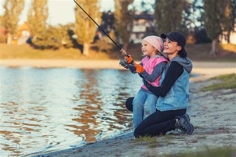 Mother And Daughter Are Fishing On The Lake Stock Photo Image Of