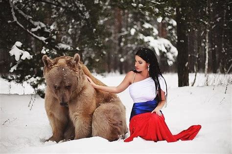 beautiful model poses for a snowy photo shoot with a friendly bear 7 pics