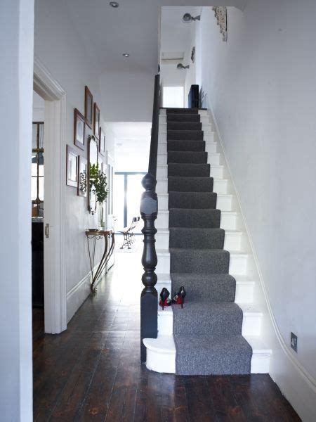 This front door pivots open into a light, bright hallway. Monochrome chic. Simple is best in a narrow hallway. White painted stairs make them appear wider ...