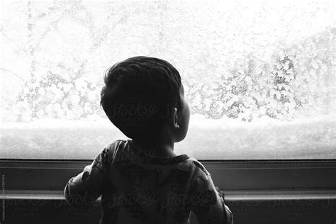 Child Looking At Snow Falling By Stocksy Contributor Lauren Lee