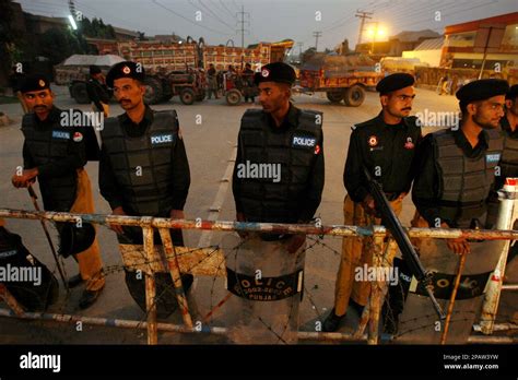 Pakistani Riot Police Guard A Barricade Outside The Residence Of Opposition Leader Benazir