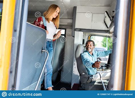 Teen Schoolgirl Walking By School Bus While Senior Driver