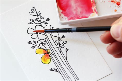 Someone Is Painting Flowers With Watercolors On Paper And Using A Brush
