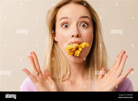 Shocked Beautiful Girl Posing With French Fries In Her Mouth Isolated