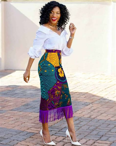 A Woman In A White Shirt And Colorful Skirt Is Posing For The Camera
