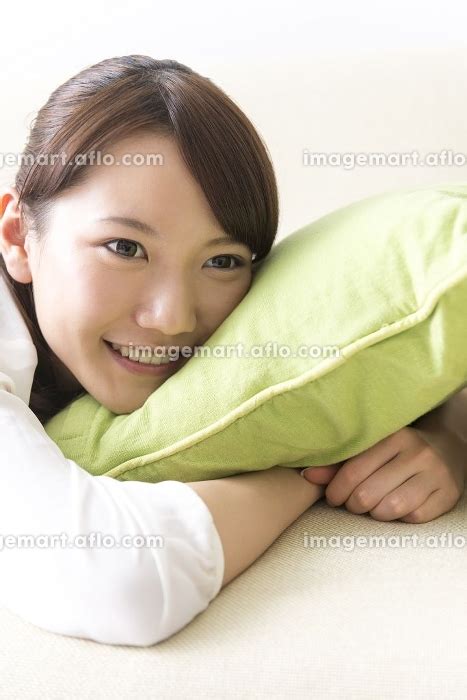 ソファで寝転ぶ女性の写真素材 24022348 イメージマート