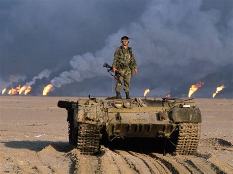 An American Soldier Standing On Top Of A Destroyed Iraqi Tank With Oil