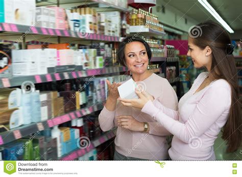 Two Laughing Women Picking Cream From Shelf Stock Image Image Of Choosing Mature 76269277