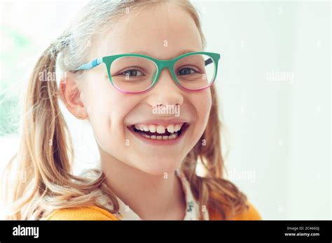 Portrait Of Happy Pretty Teen Girl In Glasses Smiling On Window