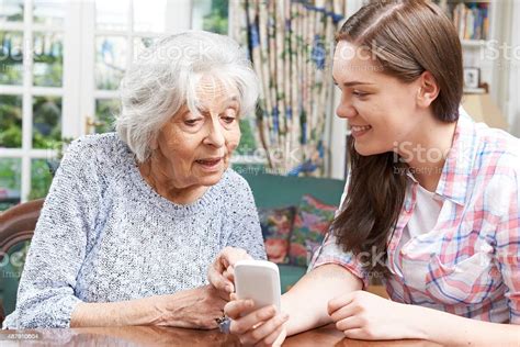 Teenage Granddaughter Showing Grandmother How To Use Mobile Phon Stock