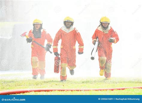 Three Firefighters On Fire Scene Walking Into A Building Royalty Free