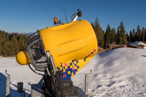 Snow Making Machine At A Local Ski Resort With Green Forest And Stock