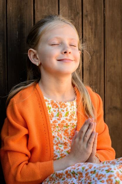 Premium Photo Mindful Girl With Praying Hands Against Wooden Wall