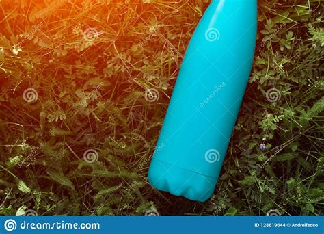 stainless thermos water bottle matte light blue color mockup isolated  green grass