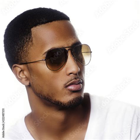 Portrait Of A Young Black Man Wearing Sunglasses Against Modern Bright White Background Stock