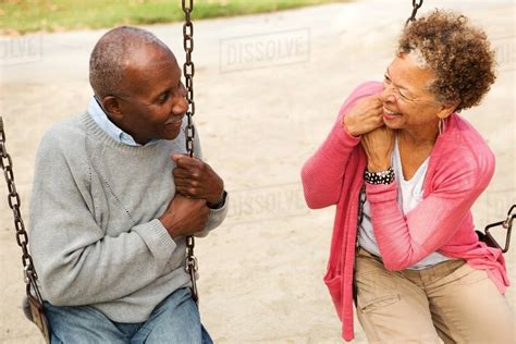 Senior Couple On Swings In Park Stock Photo Dissolve