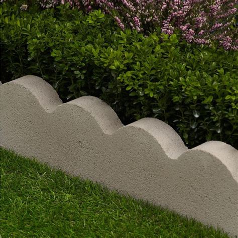 A Cement Bench Sitting In The Grass Near Some Bushes