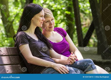 Girlfriends Sitting On Park Bench Holding Hands Horizontal Stock Image Image Of Nature