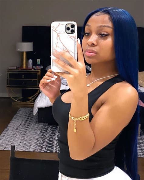 a woman with blue hair taking a selfie in her mirror while wearing a black top and white skirt