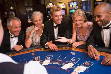 We love playing card games with friends and family, that's why we created cardzmania. Five people sitting around blackjack table in casino | Stock Photo | Colourbox