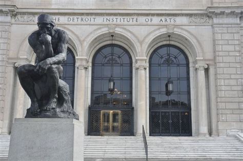 There Is A Statue Sitting In Front Of The Detroit Institute Of Arts On