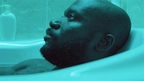 Close Up Shot Of African American Man Lying In Water And Closing His