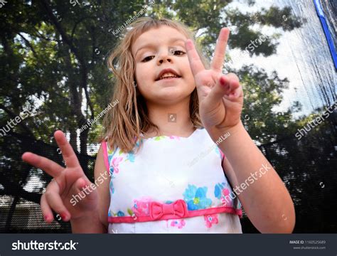 Fouryearold Girl Making Peace Signs Her Stock Photo 1160525689