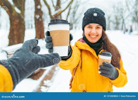Woman Give Cup Of Coffee To Friend Meeting In Snowed Winter Park Stock