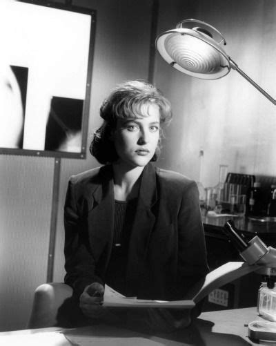 A Woman Sitting At A Desk In Front Of A Lamp