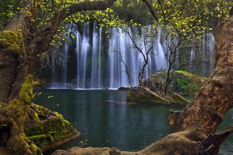 Beautiful Waterfalls Framed In Trees Over Emerald Water In Deep Green